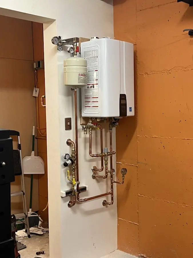 Plumbing technician inspecting water heater connections in Bargersville